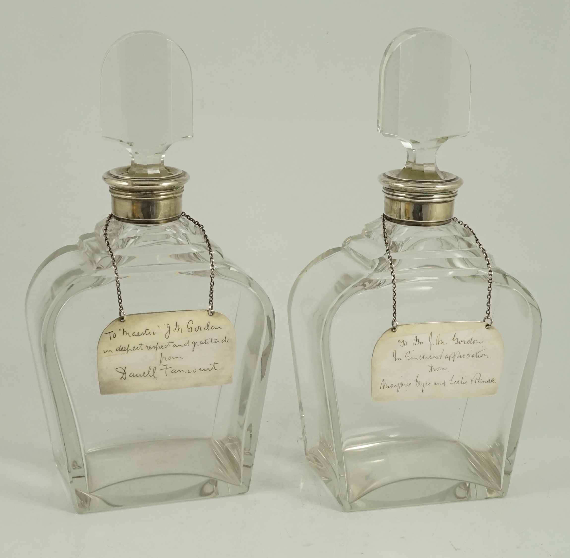 A pair of George VI silver mounted glass decanters and stoppers, by Adie Bros, presented to Mr. J.M. Gordon, to celebrate fifty five years with the D'Oyly Carte Opera Company